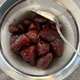 roasted strawberries in a strainer over a bowl